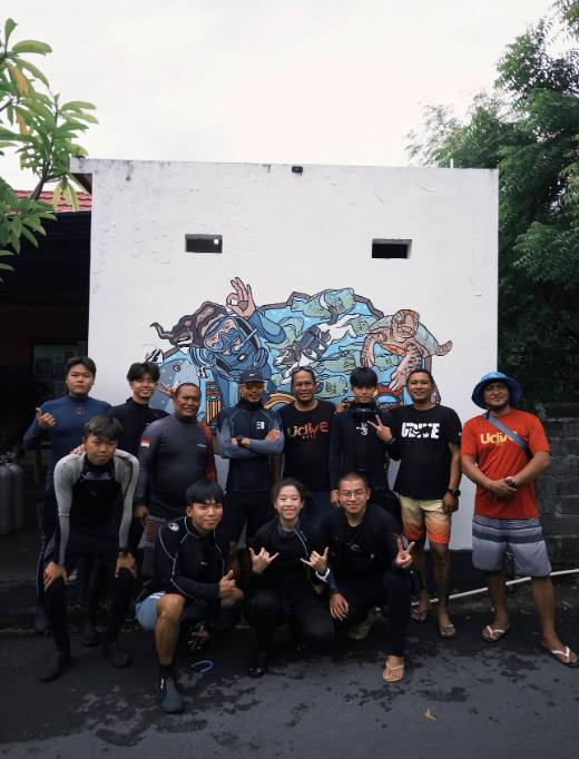 UDive Bali divers group photo by the ocean mural